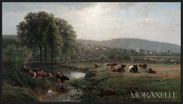 Pastoral landscape with cows grazing beside a calm stream, green trees, and distant hills.
