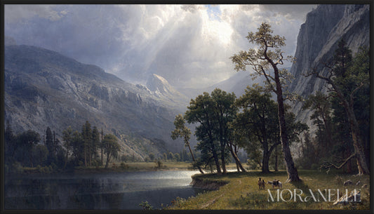 Mountain landscape with tall peaks, green slopes, a calm lake, and sunlight breaking through clouds.